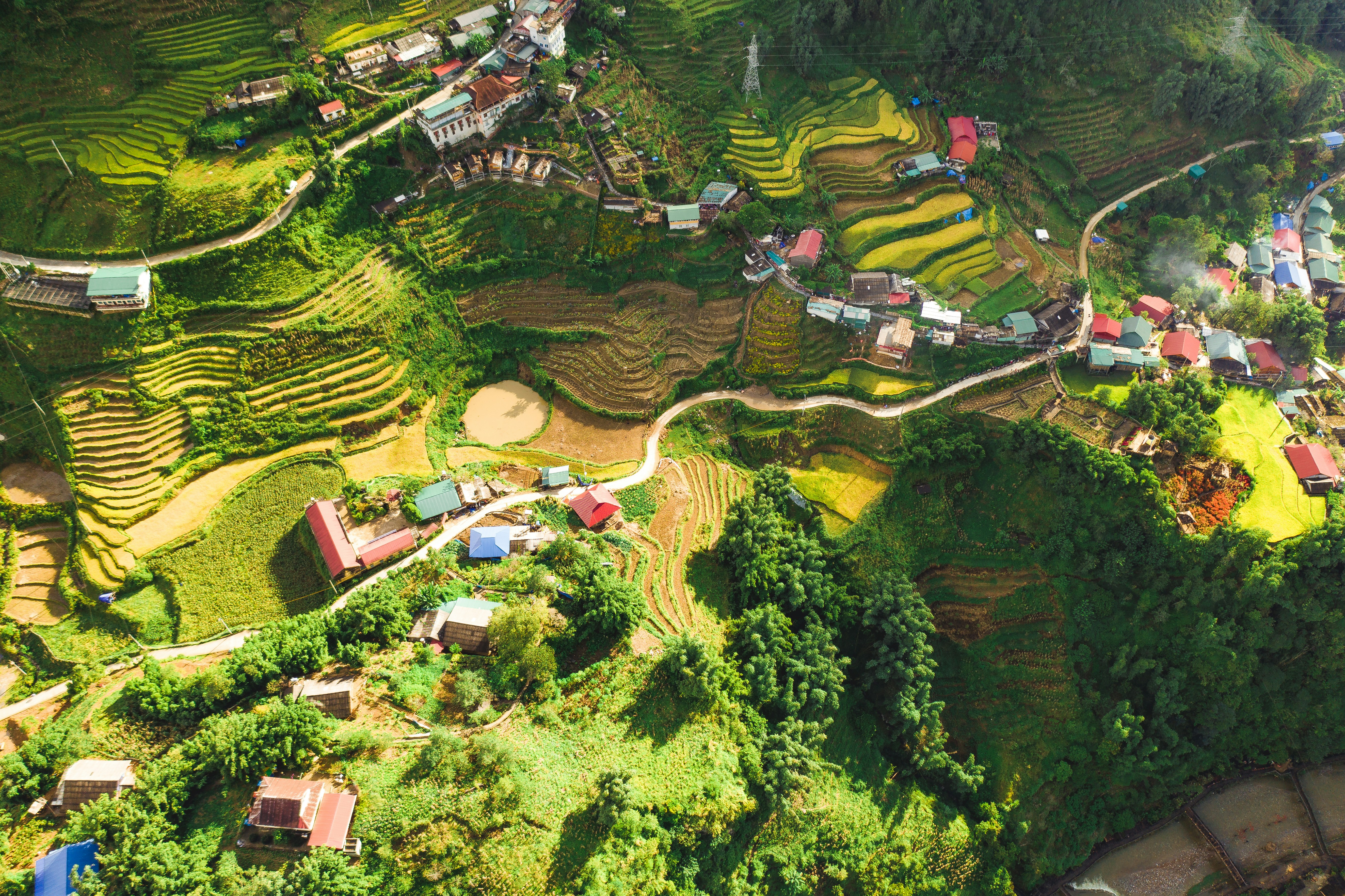 Panoramic view of Sapa rice terraces with traditional houses and misty mountains